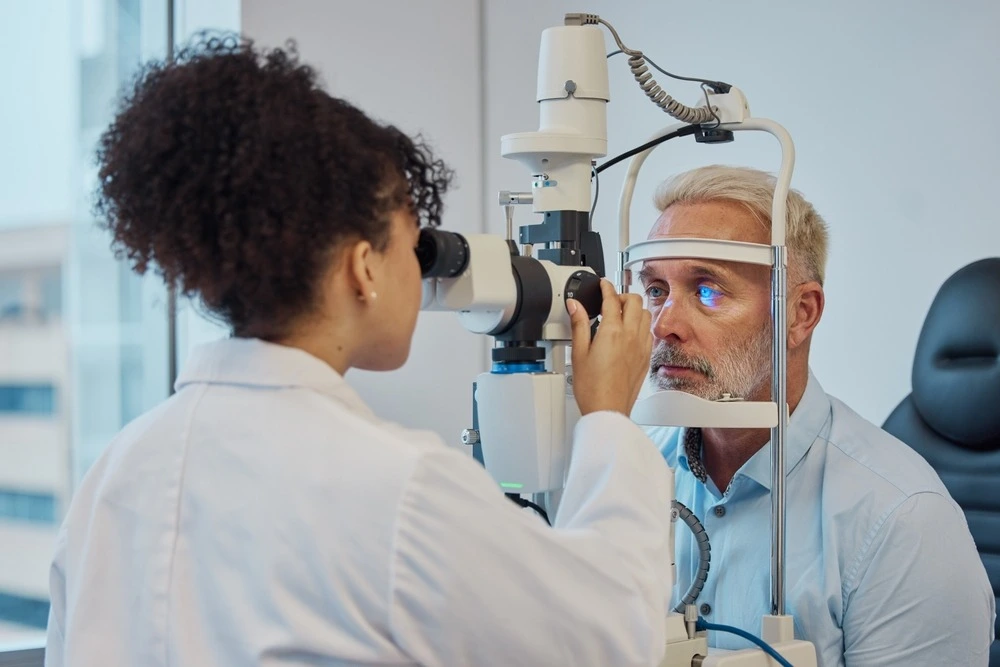 A female optometrist conducting an eye exam on a male patient
